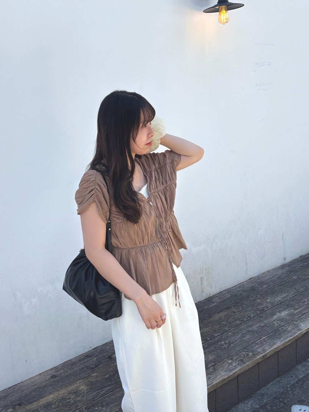 ホワイト系のスラックス、ブラウン系のシャツ/ブラウス、ホワイト系のキャミソールを着用したレディースの夏コーディネートの2枚目の写真