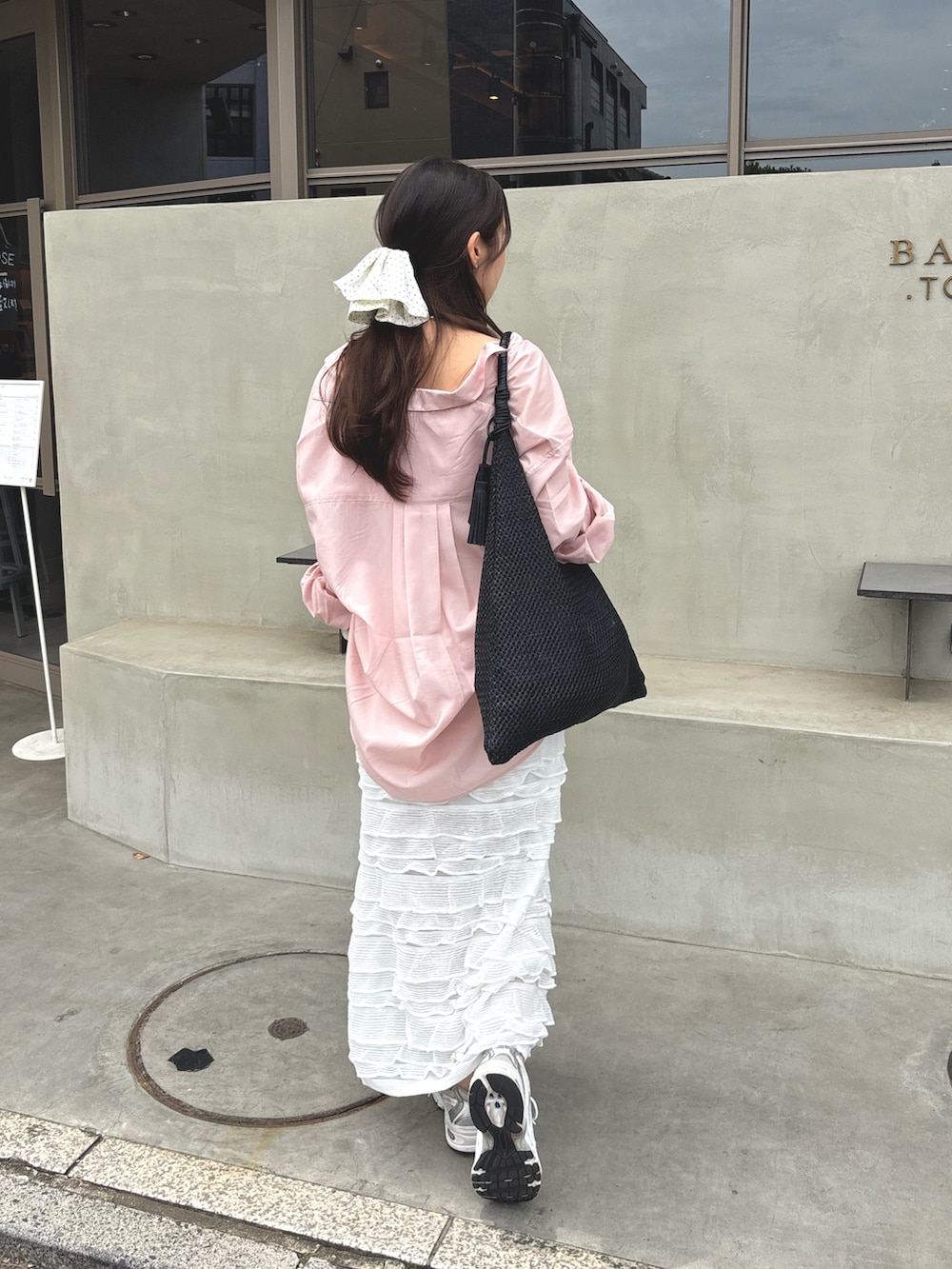 ホワイト系のスニーカー、ピンク系のシャツ/ブラウス、ブラック系のトートバッグを着用したレディースの夏コーディネートの2枚目の写真