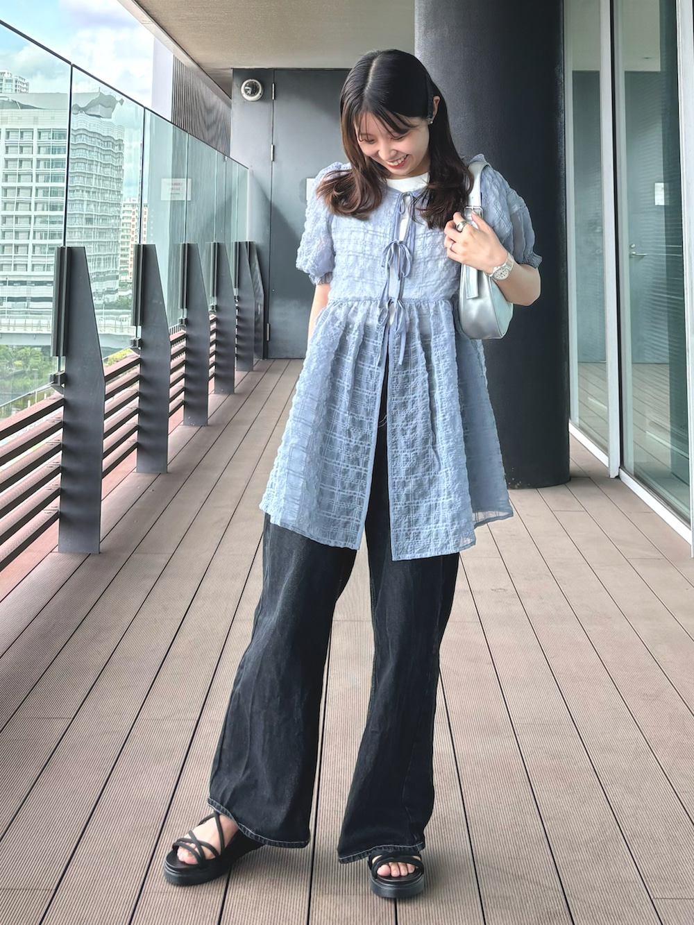 ブラック系のデニムパンツ、ホワイト系のTシャツ/カットソー、グレー系のチュニックを着用したレディースの夏コーディネートの3枚目の写真