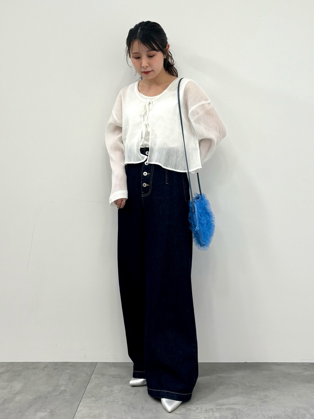 ホワイト系のシャツ/ブラウス、ブルー系のショルダーバッグ、ブルー系のデニムパンツを着用したレディースの春コーディネートの2枚目の写真