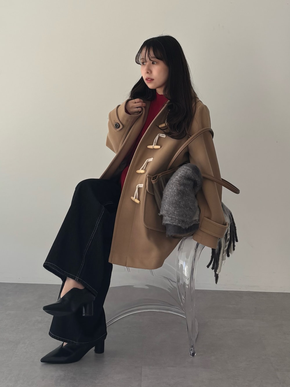 ベージュ系のダッフルコート、ブラック系のデニムパンツを着用したレディースの秋コーディネートの3枚目の写真