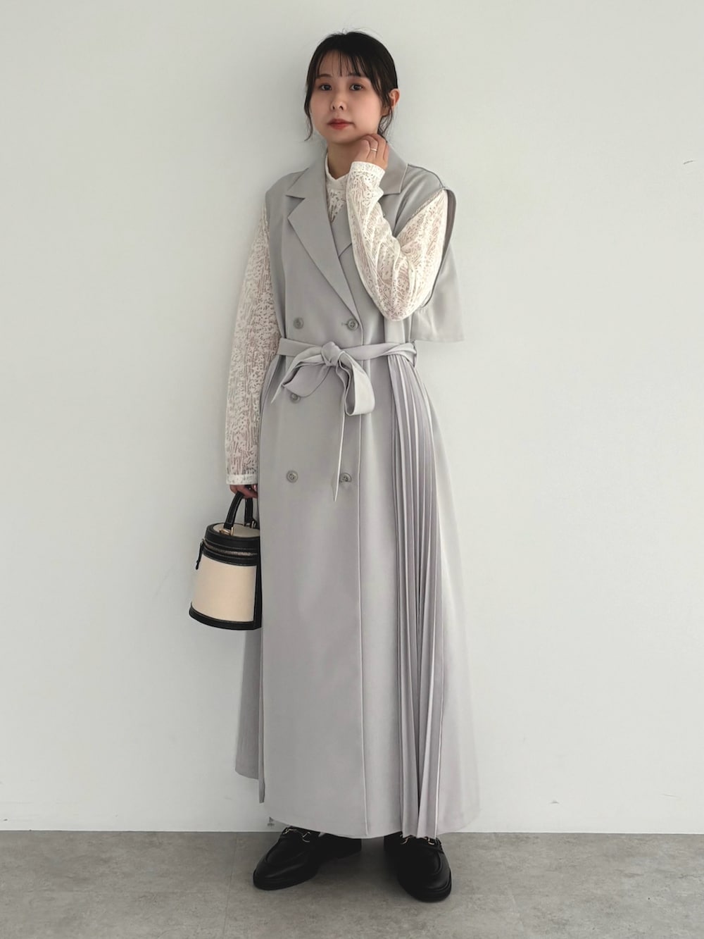 グレー系のベスト、ホワイト系のTシャツ/カットソーを着用したレディースの春コーディネートの2枚目の写真