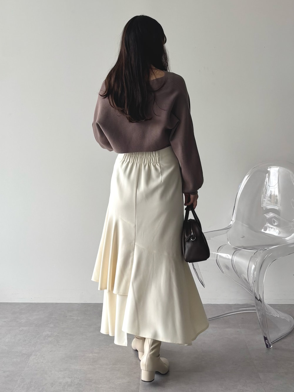 ブラウン系のニット/セーター、ホワイト系のスカートを着用したレディースの秋コーディネートの3枚目の写真