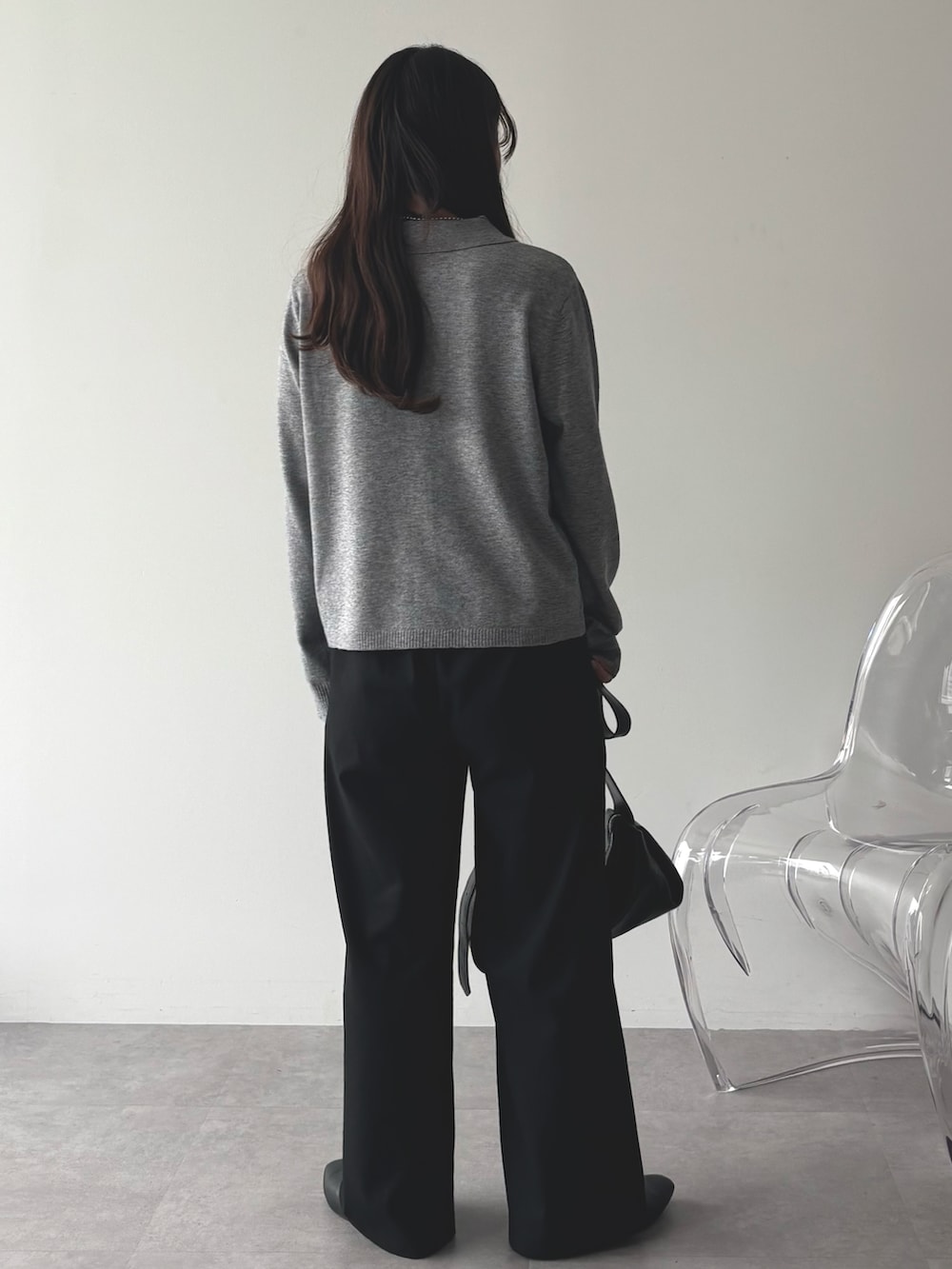 グレー系のニット/セーター、ブラック系のパンプス、ブラック系のショルダーバッグを着用したレディースの秋コーディネートの3枚目の写真