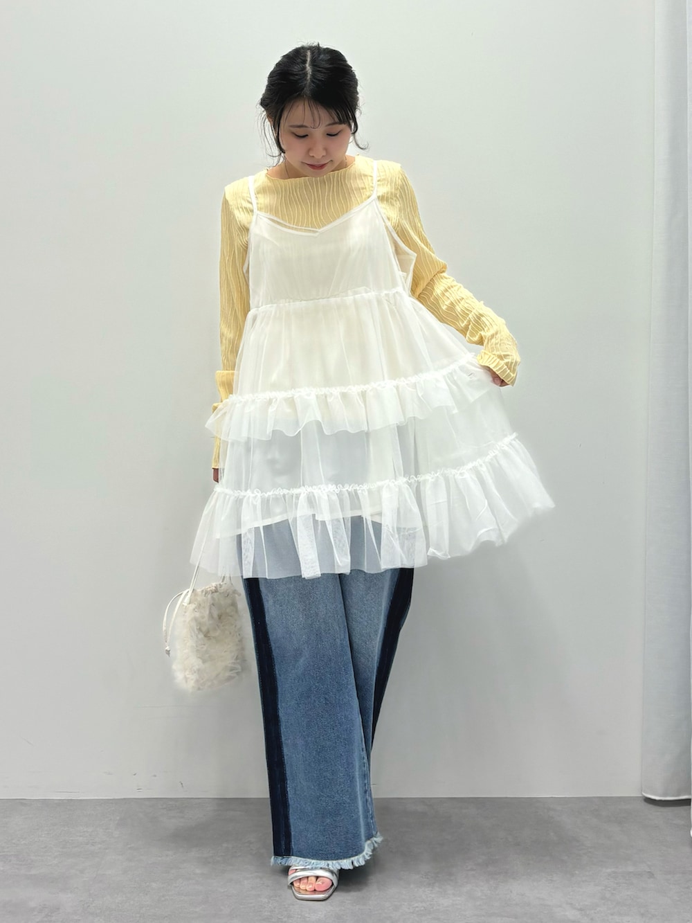 ホワイト系のワンピース、ブルー系のデニムパンツ、イエロー系のTシャツ/カットソーを着用したレディースの春コーディネートの2枚目の写真