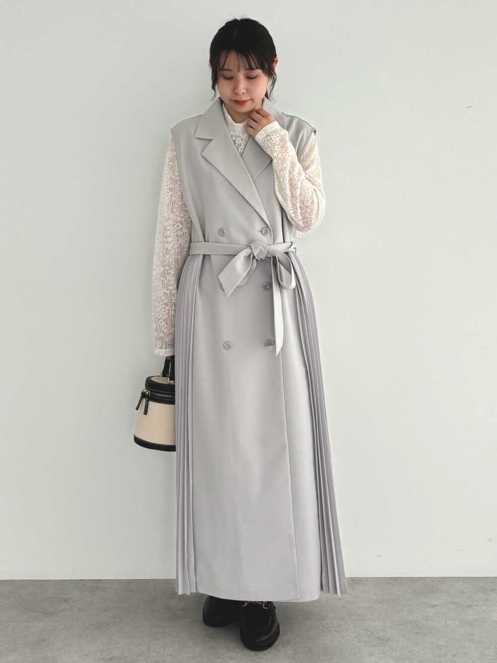 グレー系のベスト、ホワイト系のTシャツ/カットソーを着用したレディースの春コーディネートの3枚目の写真