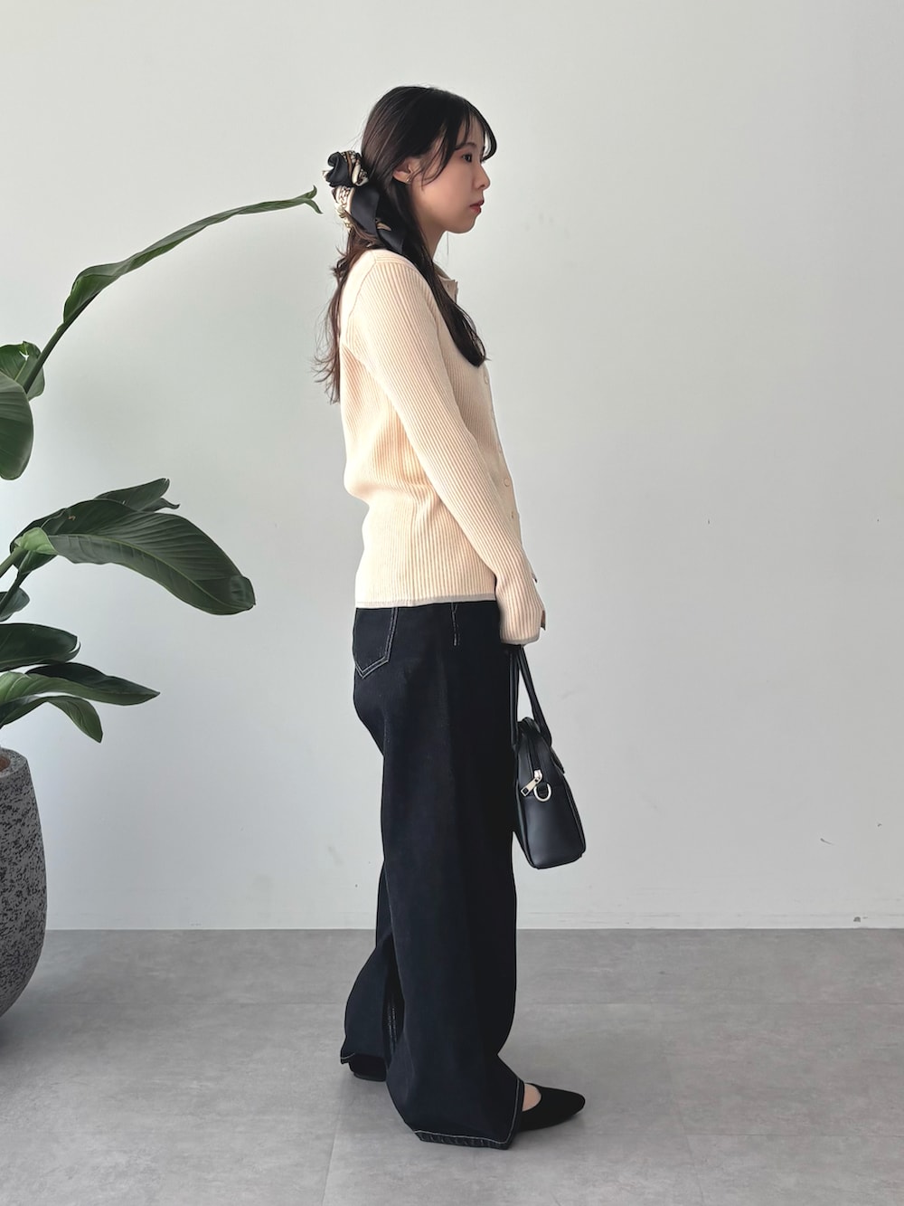 ホワイト系のニット/セーター、ブラック系のデニムパンツ、ブラック系のバンダナ/スカーフを着用したレディースの秋コーディネートの2枚目の写真