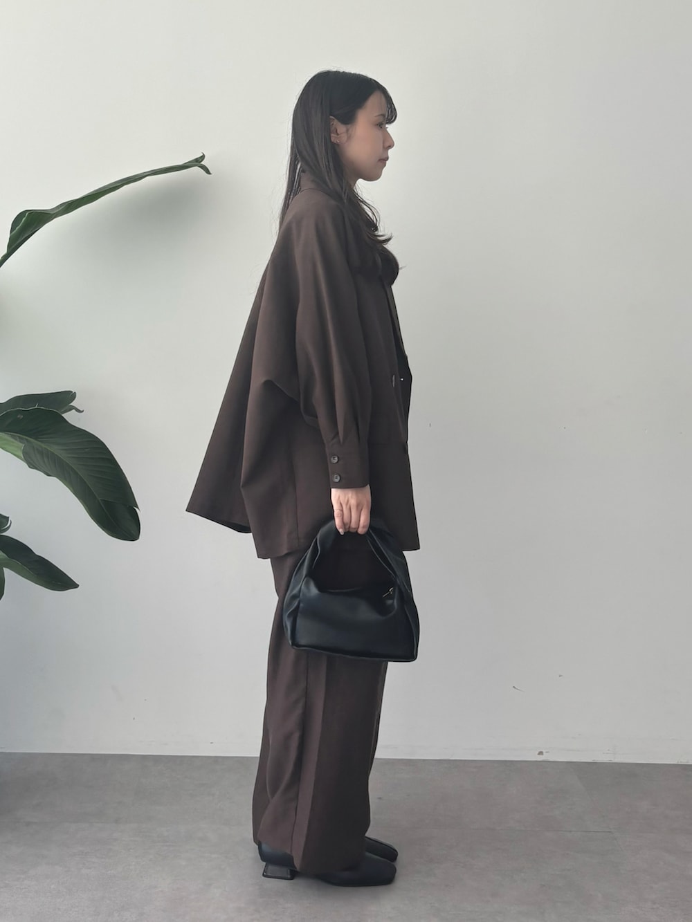 ブラウン系のブルゾン、ブラウン系のその他パンツ、ホワイト系のシャツ/ブラウスを着用したレディースの秋コーディネートの2枚目の写真
