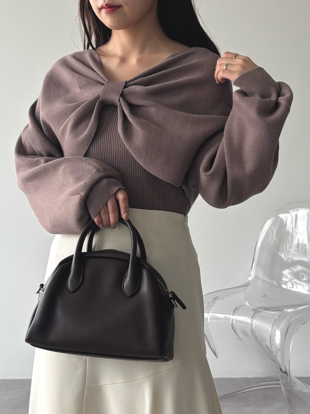 ブラウン系のニット/セーター、ホワイト系のスカートを着用したレディースの秋コーディネートの4枚目の写真