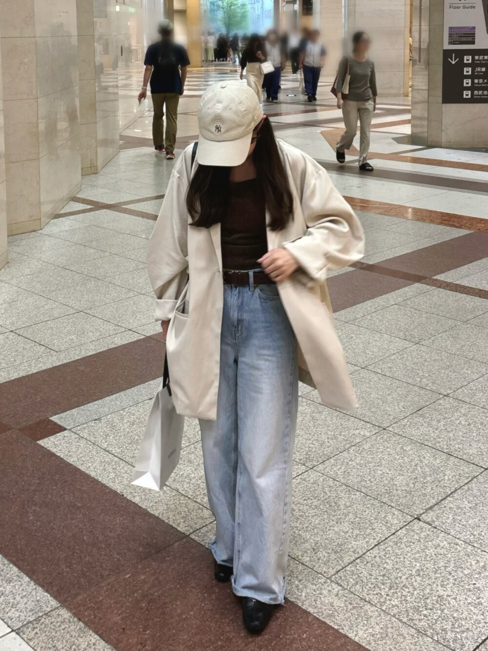 ブラウン系のキャミソール、ブルー系のデニムパンツ、ホワイト系のテーラードジャケットを着用したレディースの秋コーディネートの2枚目の写真