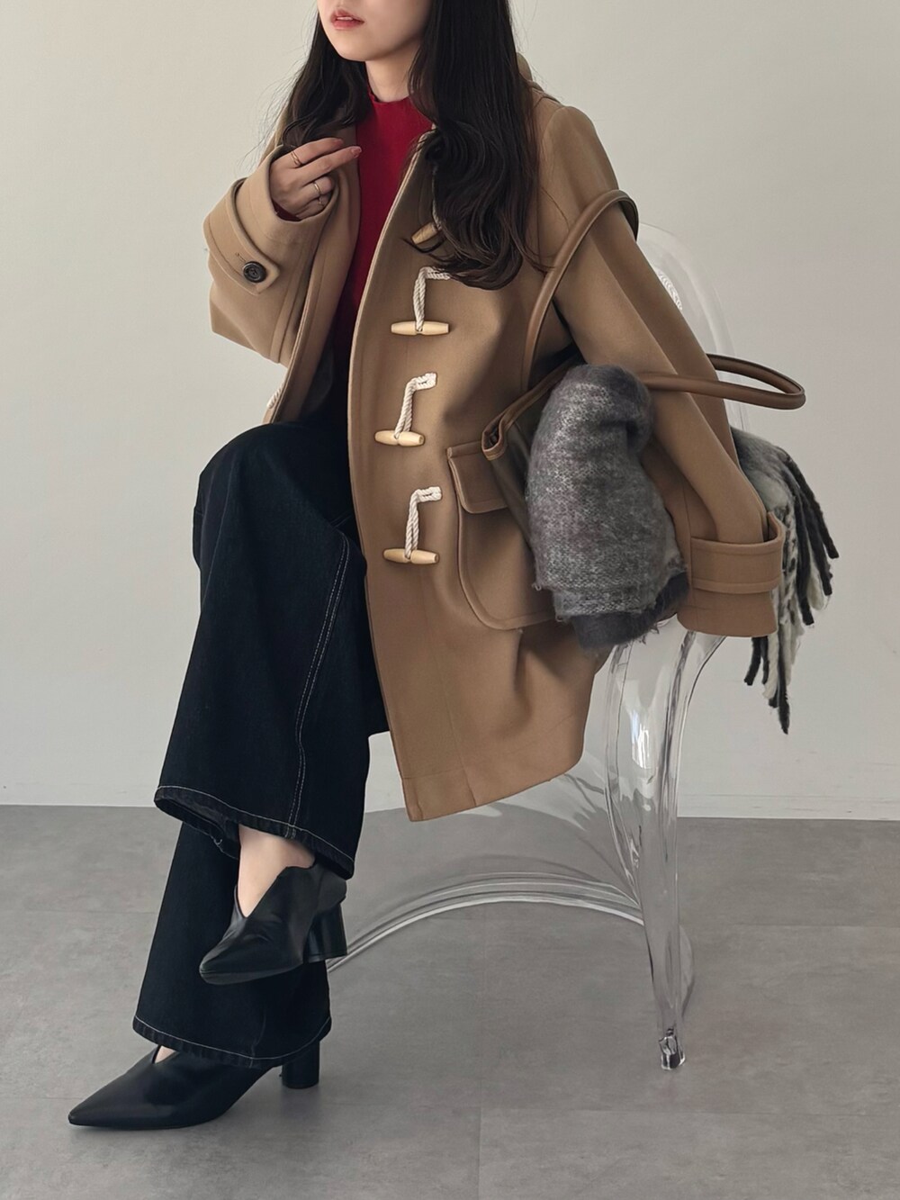 ベージュ系のダッフルコート、ブラック系のデニムパンツを着用したレディースの秋コーディネートの4枚目の写真