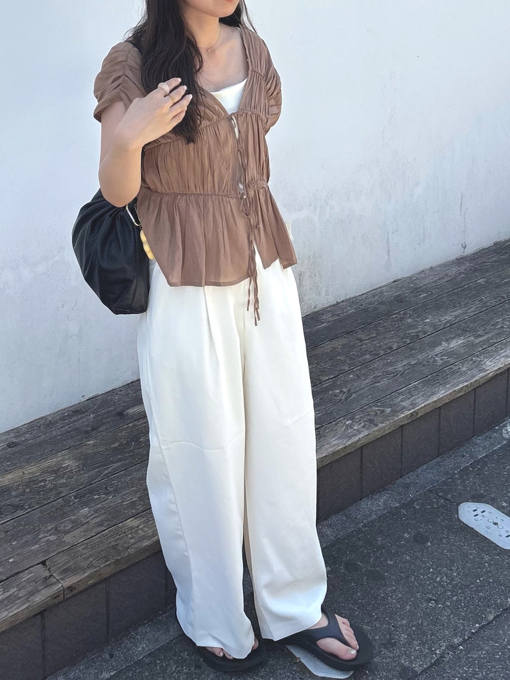 ホワイト系のスラックス、ブラウン系のシャツ/ブラウス、ホワイト系のキャミソールを着用したレディースの夏コーディネートの3枚目の写真