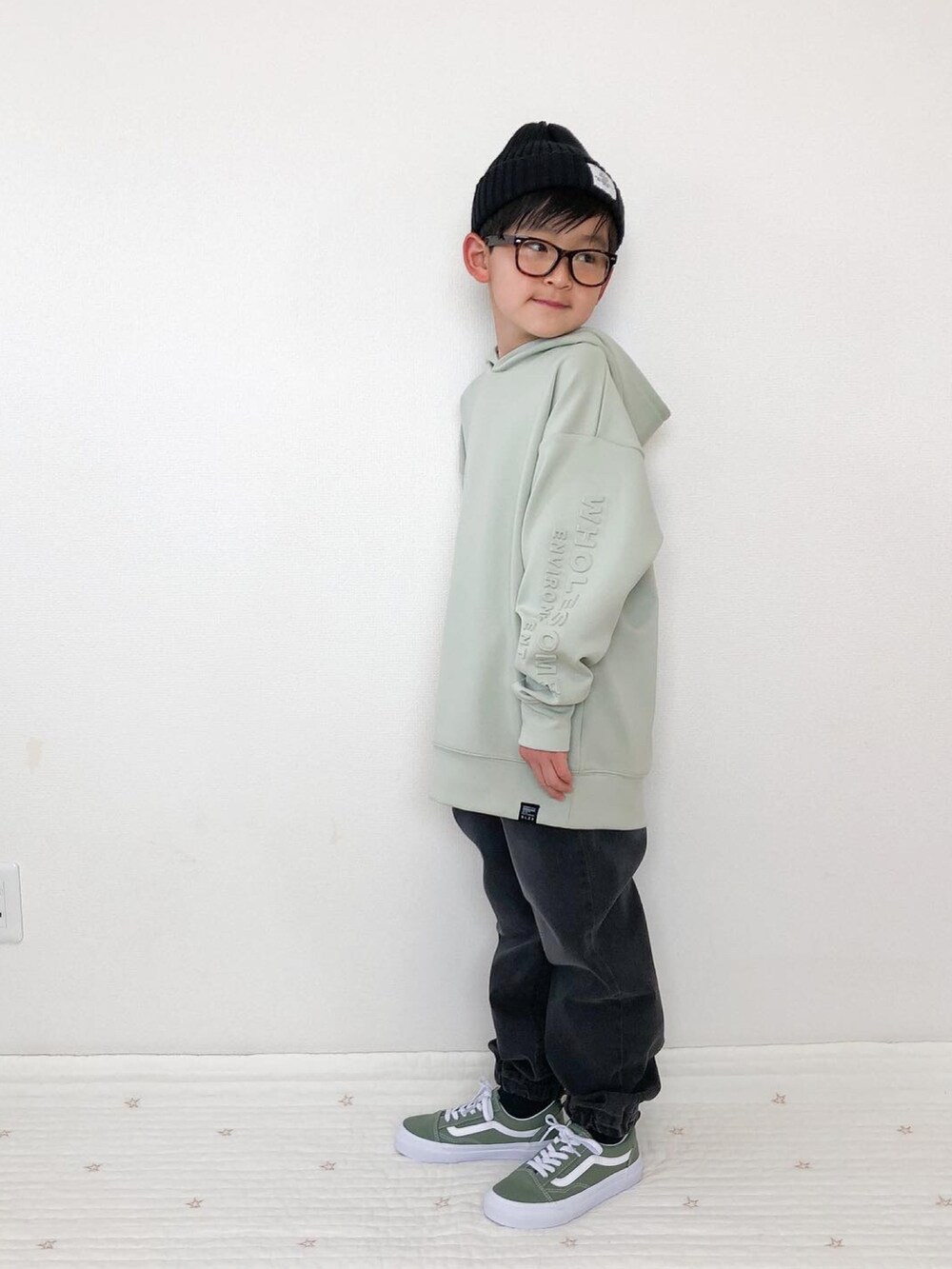 グレー系のデニムパンツ、グリーン系のスニーカー、グリーン系のパーカーを着用したキッズの春コーディネートの3枚目の写真