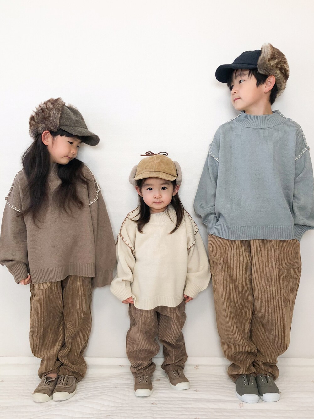 ブラウン系のその他パンツ、ブルー系のニット/セーター、ホワイト系のニット/セーターを着用したキッズの冬コーディネートの2枚目の写真