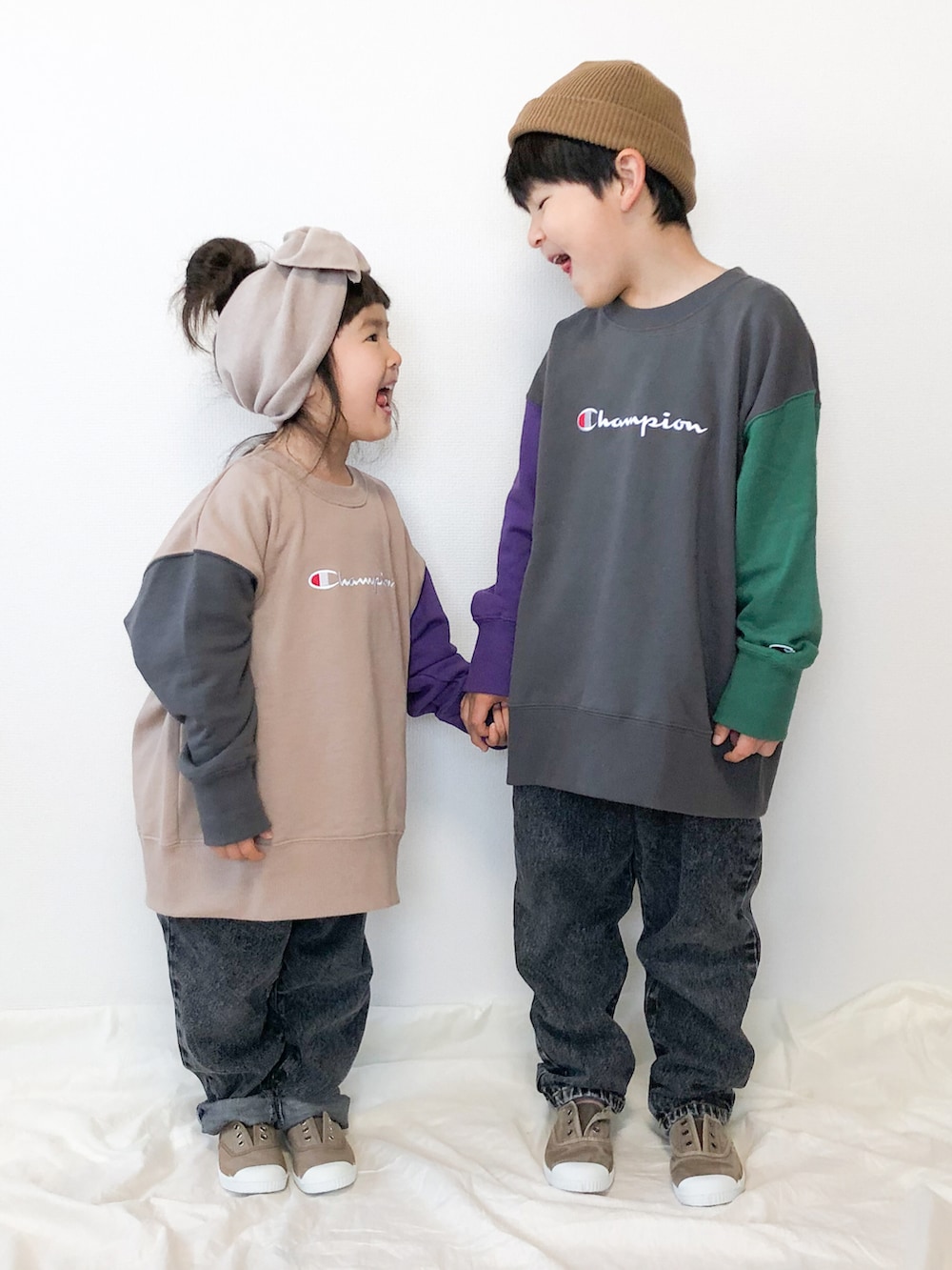 グレー系のスウェット、ベージュ系のスウェット、ブラック系のデニムパンツを着用したキッズの秋コーディネートの2枚目の写真