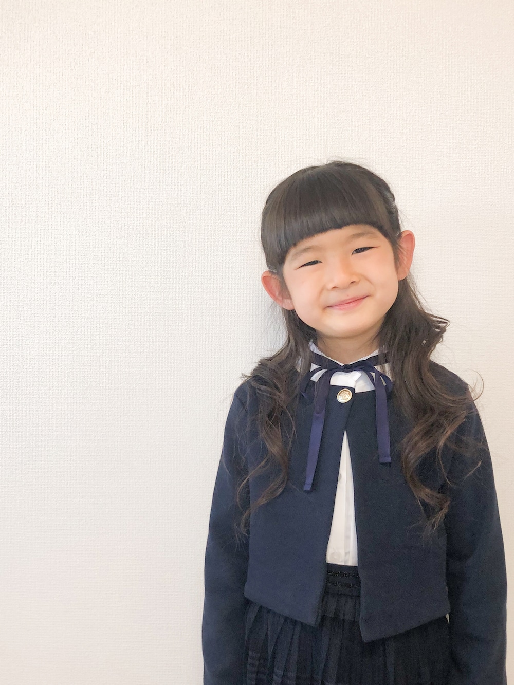 ブラック系のドレスシューズ、ホワイト系のシャツ/ブラウス、ブルー系のスカートを着用したキッズの春コーディネートの3枚目の写真