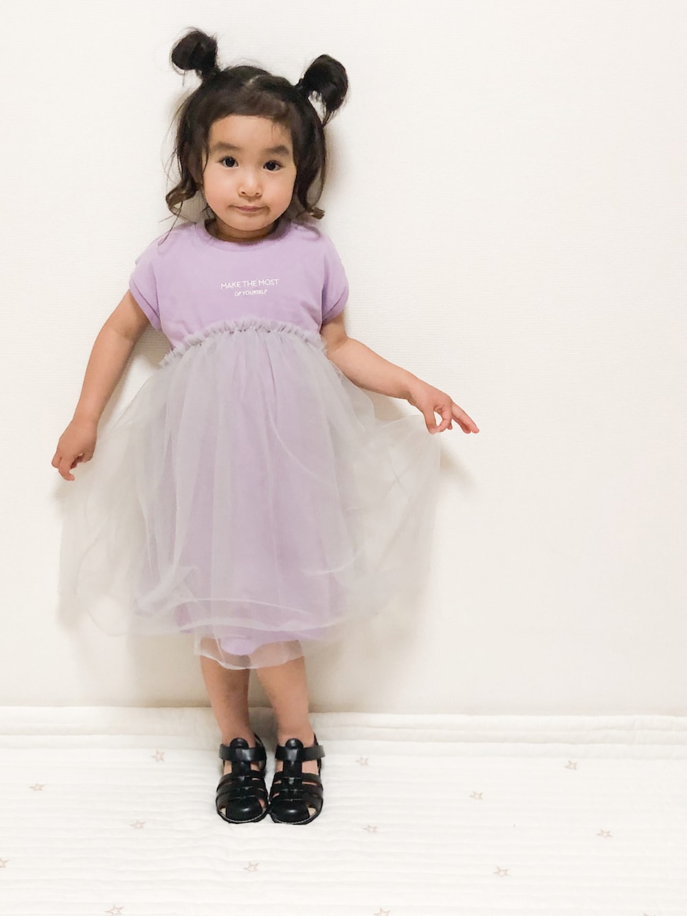 パープル系のワンピース、ブラック系のサンダルを着用したキッズの夏コーディネートの2枚目の写真