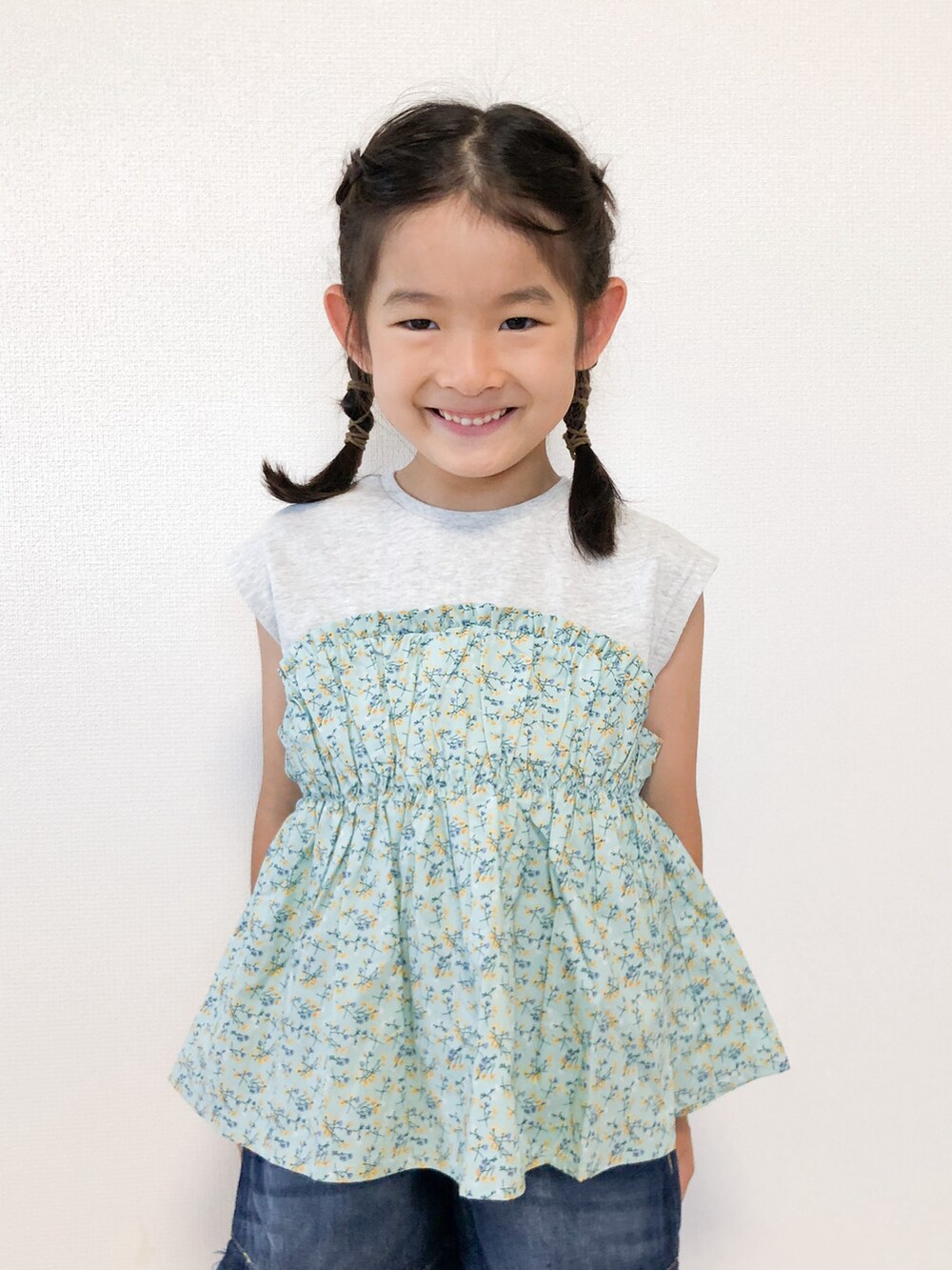 グリーン系のTシャツ/カットソー、ブルー系のデニムパンツ、ブラック系のスニーカーを着用したキッズの秋コーディネートの2枚目の写真