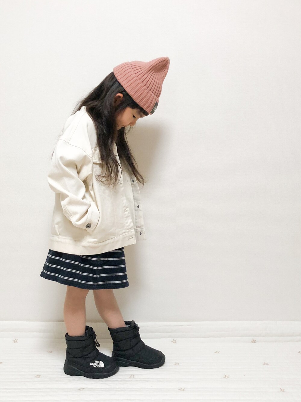 ホワイト系のデニムジャケット、ブラック系のブーツ、ピンク系のキャップを着用したキッズの春コーディネートの4枚目の写真