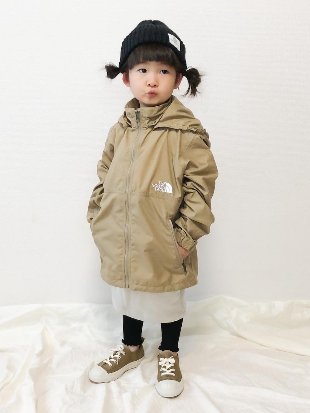 ベージュ系のその他アウター、ホワイト系のスカート、グリーン系のスニーカーを着用したキッズの春コーディネートの2枚目の写真