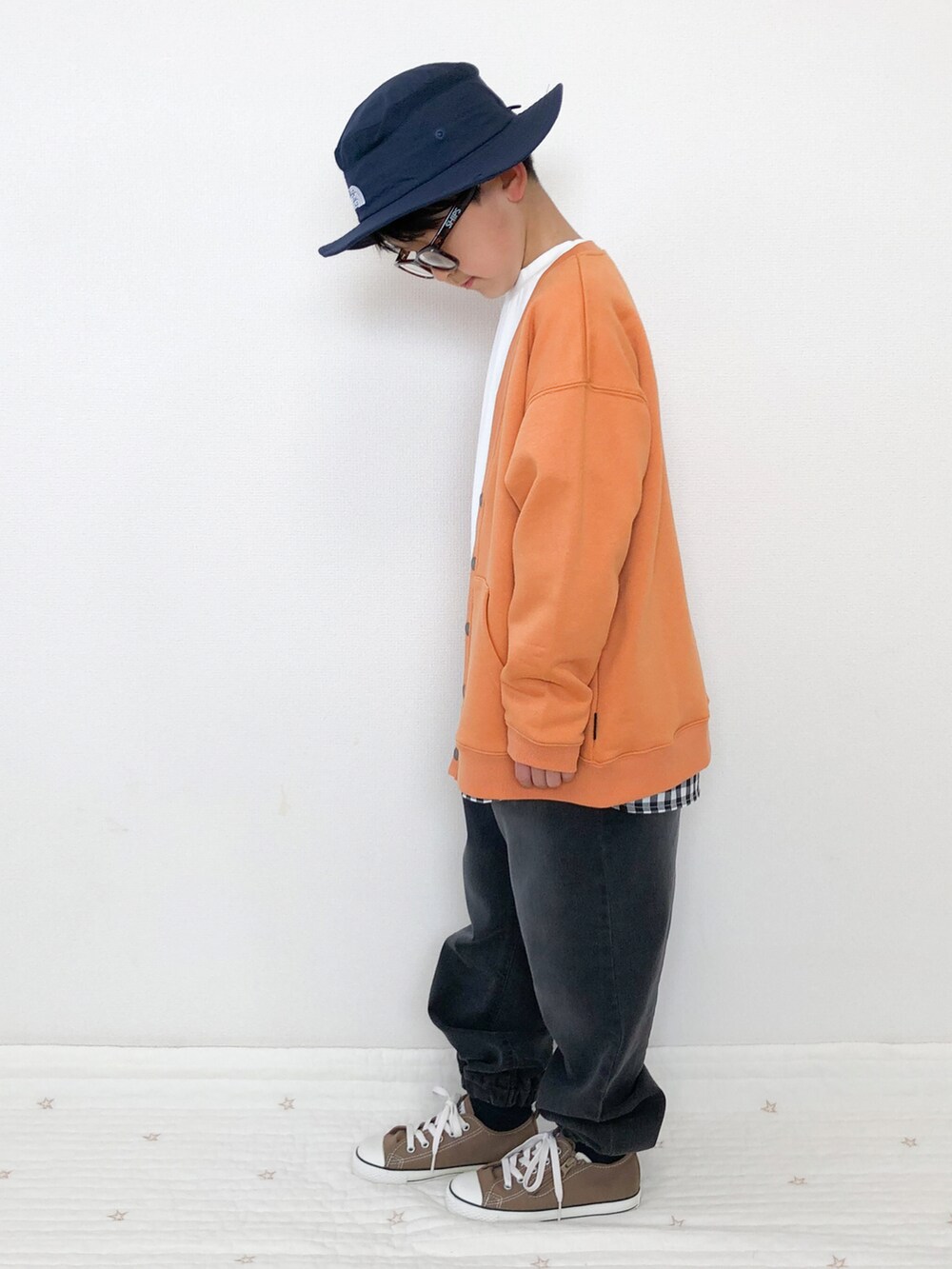 グレー系のデニムパンツ、オレンジ系のカーディガン/ボレロ、ホワイト系のTシャツ/カットソーを着用したキッズの春コーディネートの2枚目の写真