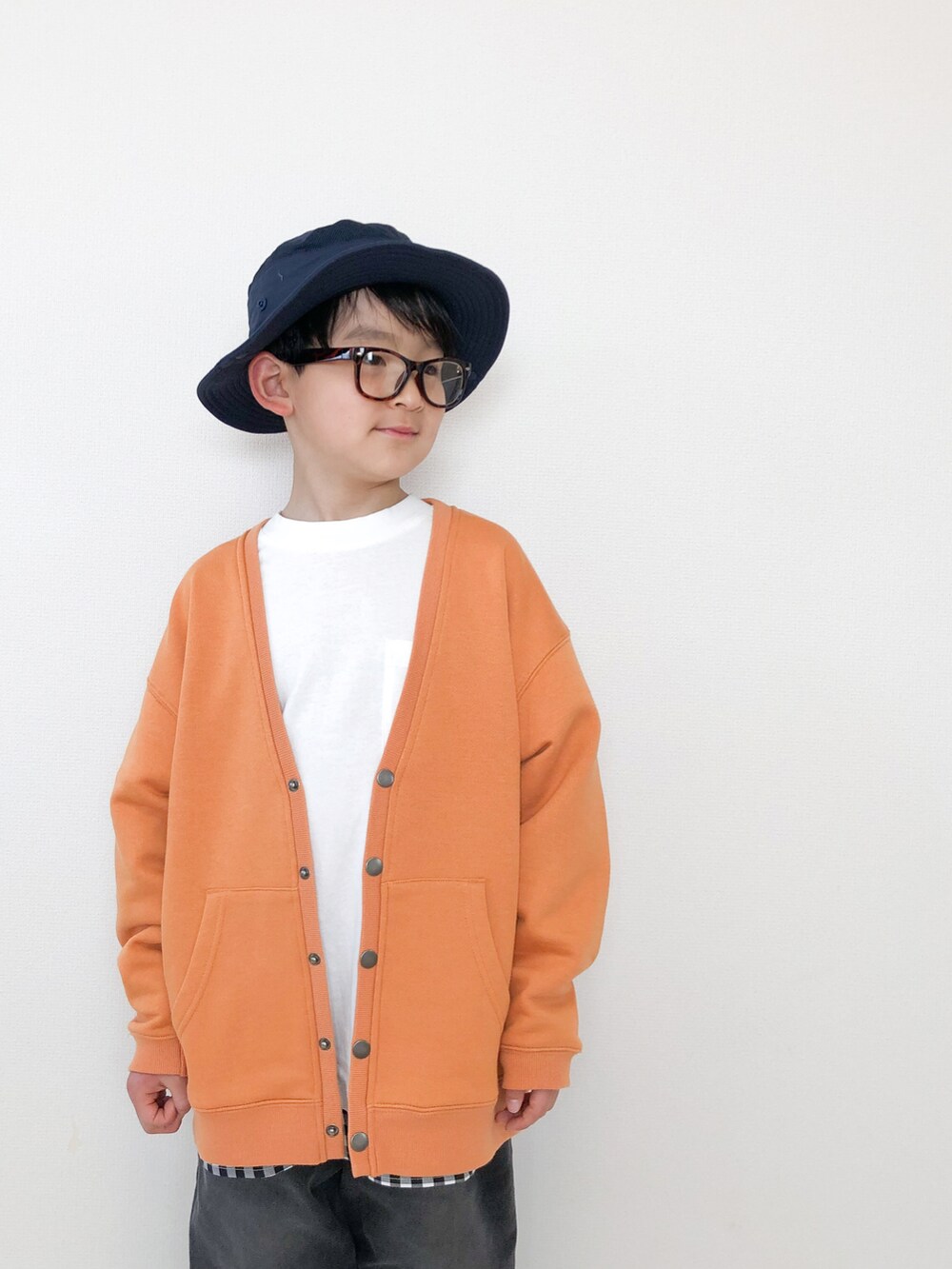 グレー系のデニムパンツ、オレンジ系のカーディガン/ボレロ、ホワイト系のTシャツ/カットソーを着用したキッズの春コーディネートの3枚目の写真