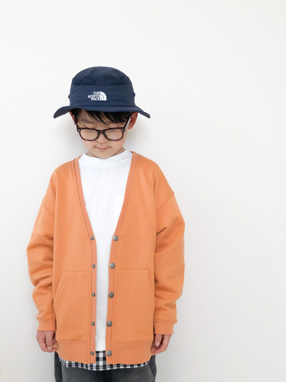 グレー系のデニムパンツ、オレンジ系のカーディガン/ボレロ、ホワイト系のTシャツ/カットソーを着用したキッズの春コーディネートの4枚目の写真