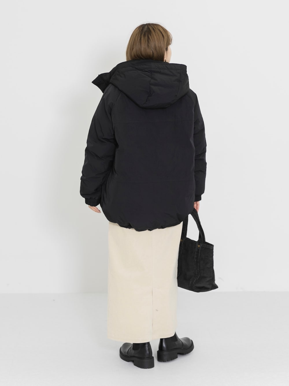 ホワイト系のTシャツ/カットソー、ホワイト系のスカート、グレー系のトートバッグを着用したレディースの冬コーディネートの4枚目の写真