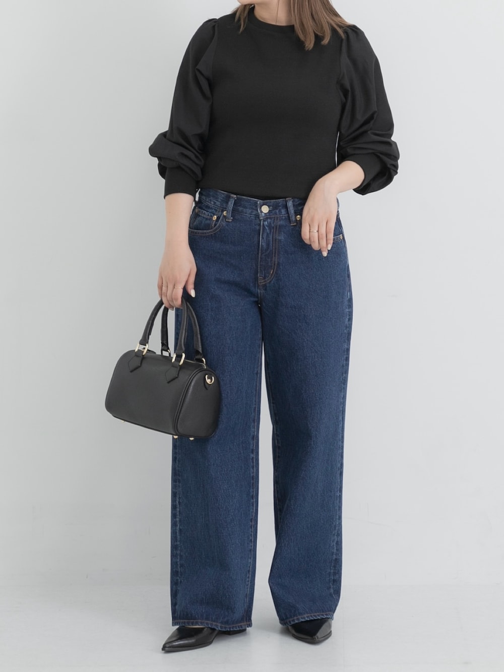 ブルー系のデニムパンツ、ブラック系のボストンバッグ、ブラック系のその他シューズを着用したレディースの秋コーディネートの4枚目の写真