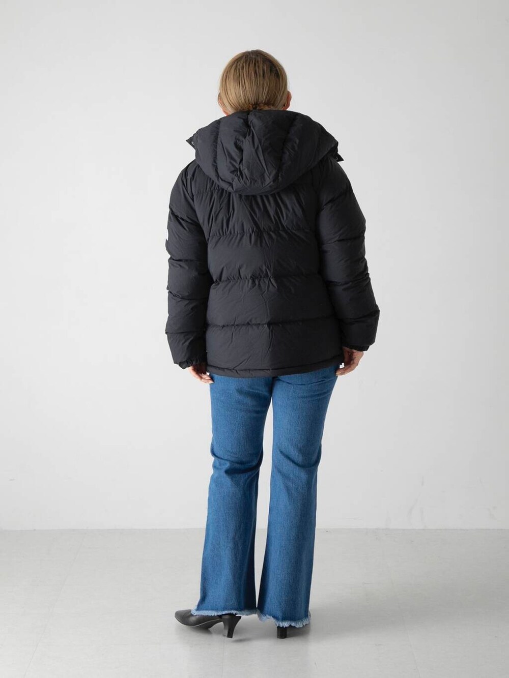 ホワイト系のニット/セーター、ブラック系のその他シューズ、ブルー系のデニムパンツを着用したレディースの秋コーディネートの3枚目の写真