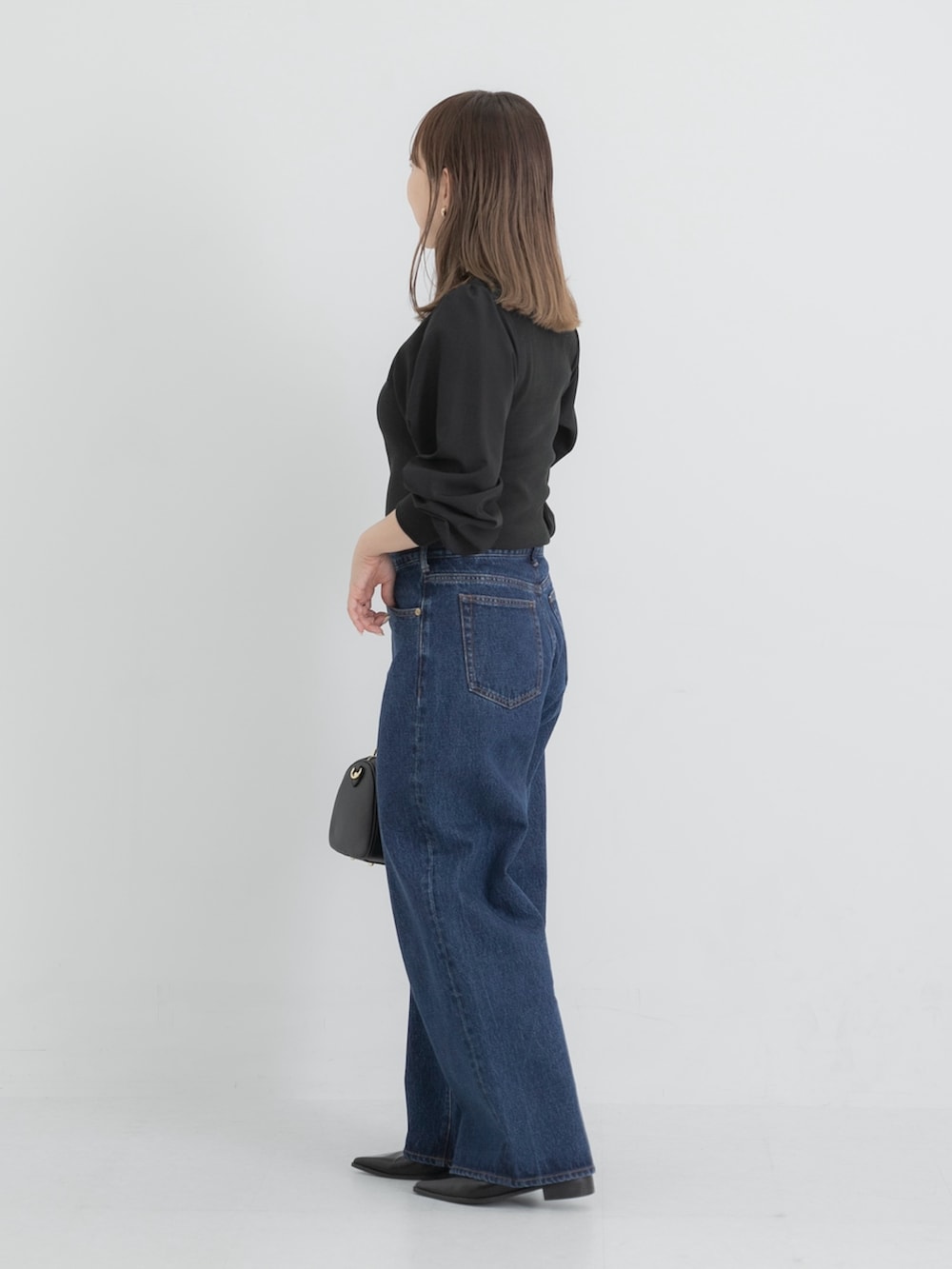 ブルー系のデニムパンツ、ブラック系のボストンバッグ、ブラック系のその他シューズを着用したレディースの秋コーディネートの2枚目の写真