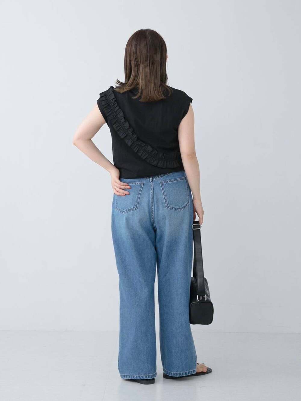 ブラック系のサンダル、ブルー系のデニムパンツ、ブラック系のTシャツ/カットソーを着用したレディースの夏コーディネートの3枚目の写真