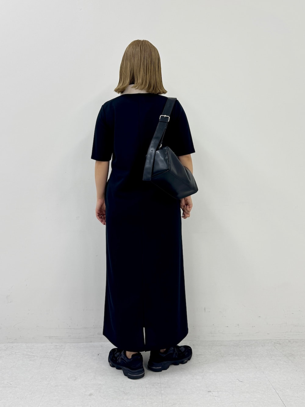 ブラック系のワンピース、ブラック系のスニーカー、ブラック系のショルダーバッグを着用したレディースの春コーディネートの3枚目の写真