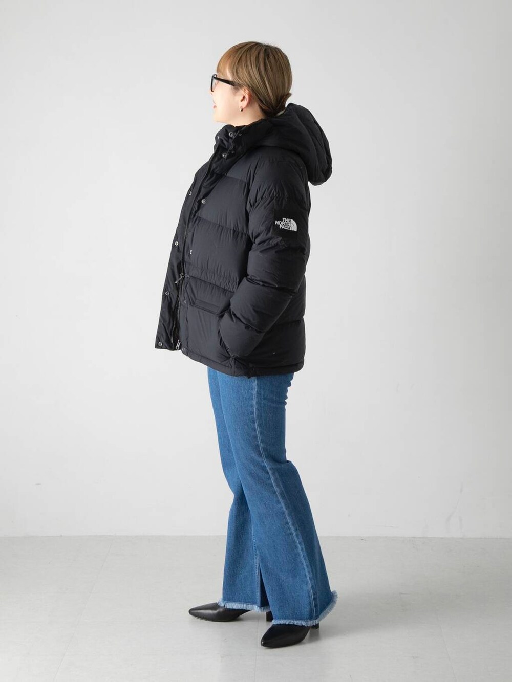 ホワイト系のニット/セーター、ブラック系のその他シューズ、ブルー系のデニムパンツを着用したレディースの秋コーディネートの2枚目の写真