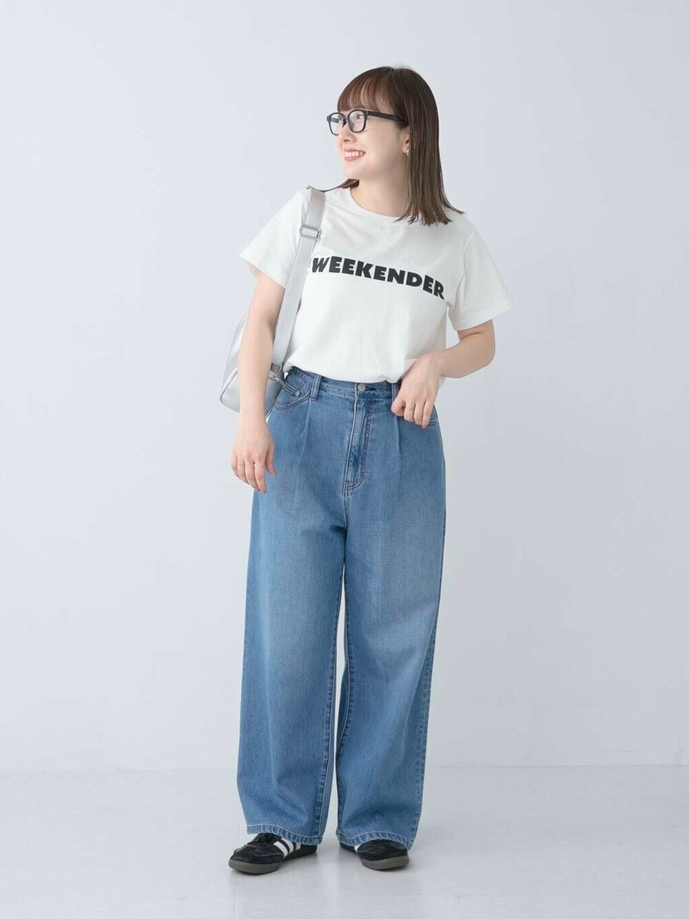 ブラック系のスニーカー、ブルー系のデニムパンツ、ホワイト系のTシャツ/カットソーを着用したレディースの夏コーディネートの2枚目の写真