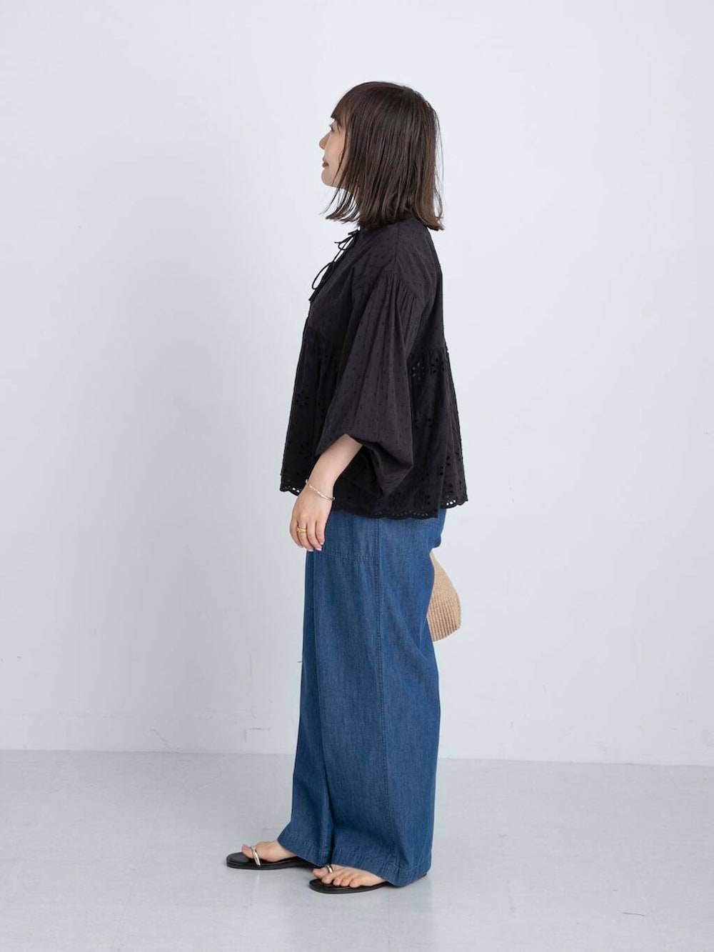 ブラック系のサンダル、ブラック系のシャツ/ブラウス、ブルー系のデニムパンツを着用したレディースの夏コーディネートの2枚目の写真