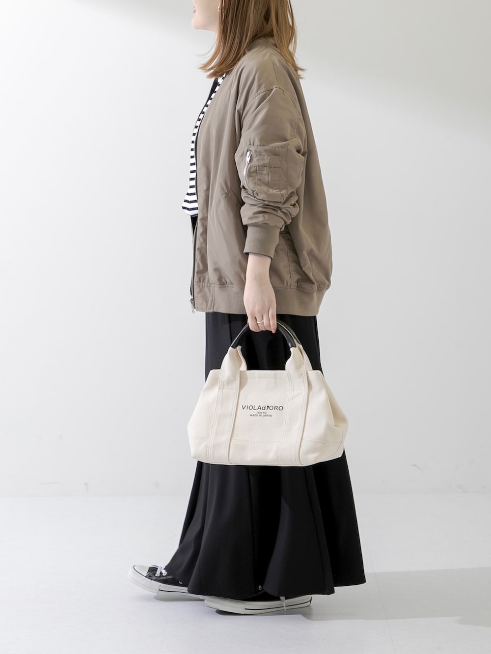 ホワイト系のトートバッグ、ブラック系のTシャツ/カットソー、ブラック系のスカートを着用したレディースの春コーディネートの3枚目の写真