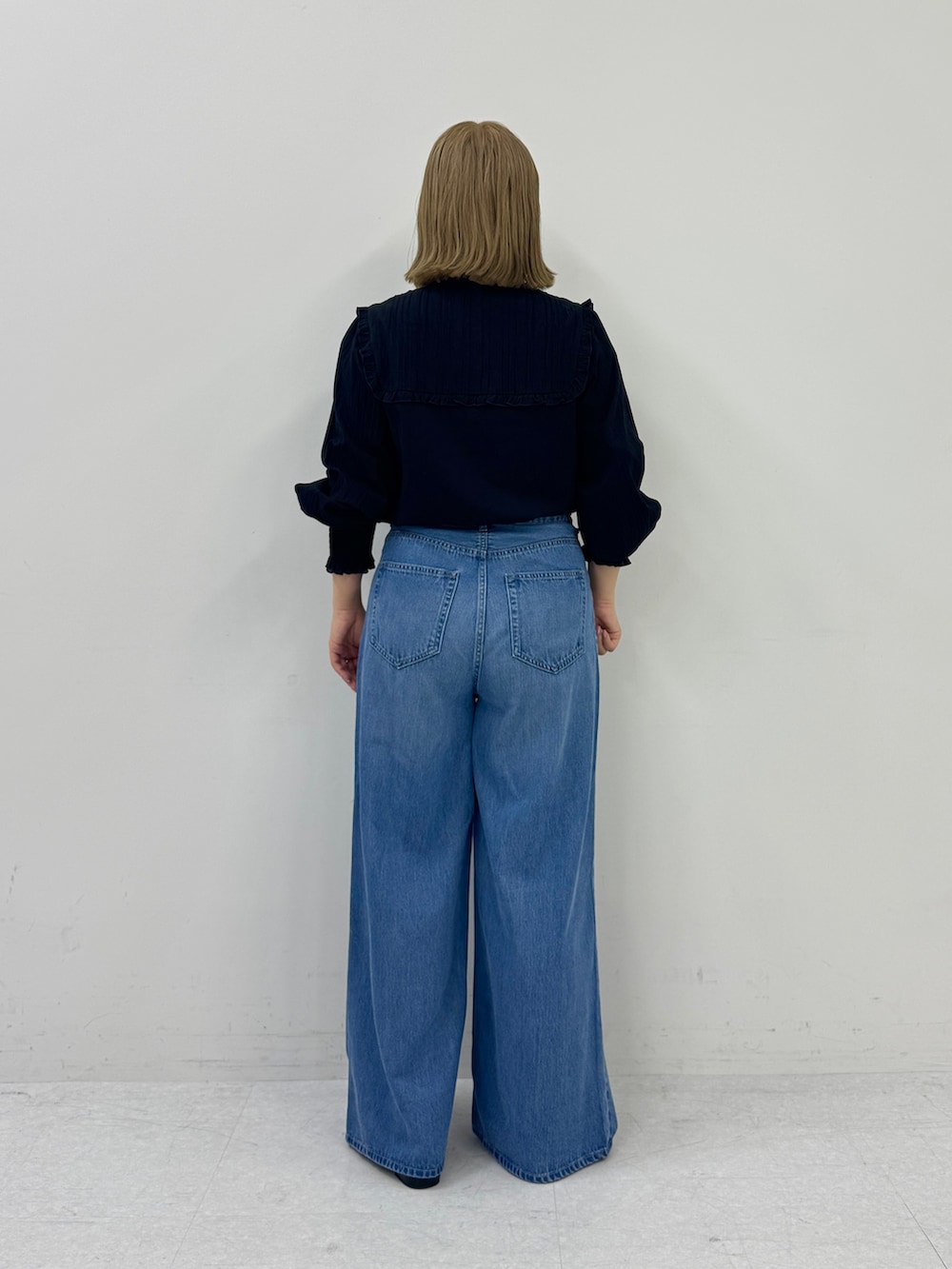 ブラック系のシャツ/ブラウス、ブルー系のデニムパンツ、ブラック系のスリッポンを着用したレディースの春コーディネートの3枚目の写真