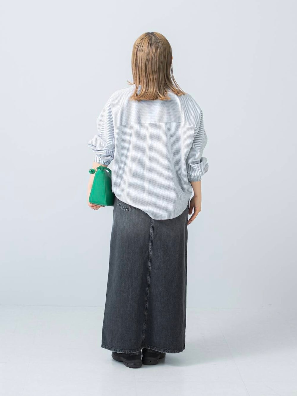 ブラック系のスニーカー、ブラック系のスカート、ホワイト系のシャツ/ブラウスを着用したレディースの冬コーディネートの3枚目の写真