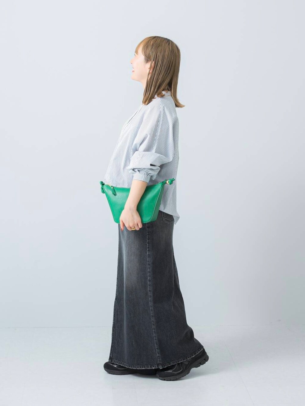 ブラック系のスニーカー、ブラック系のスカート、ホワイト系のシャツ/ブラウスを着用したレディースの冬コーディネートの2枚目の写真