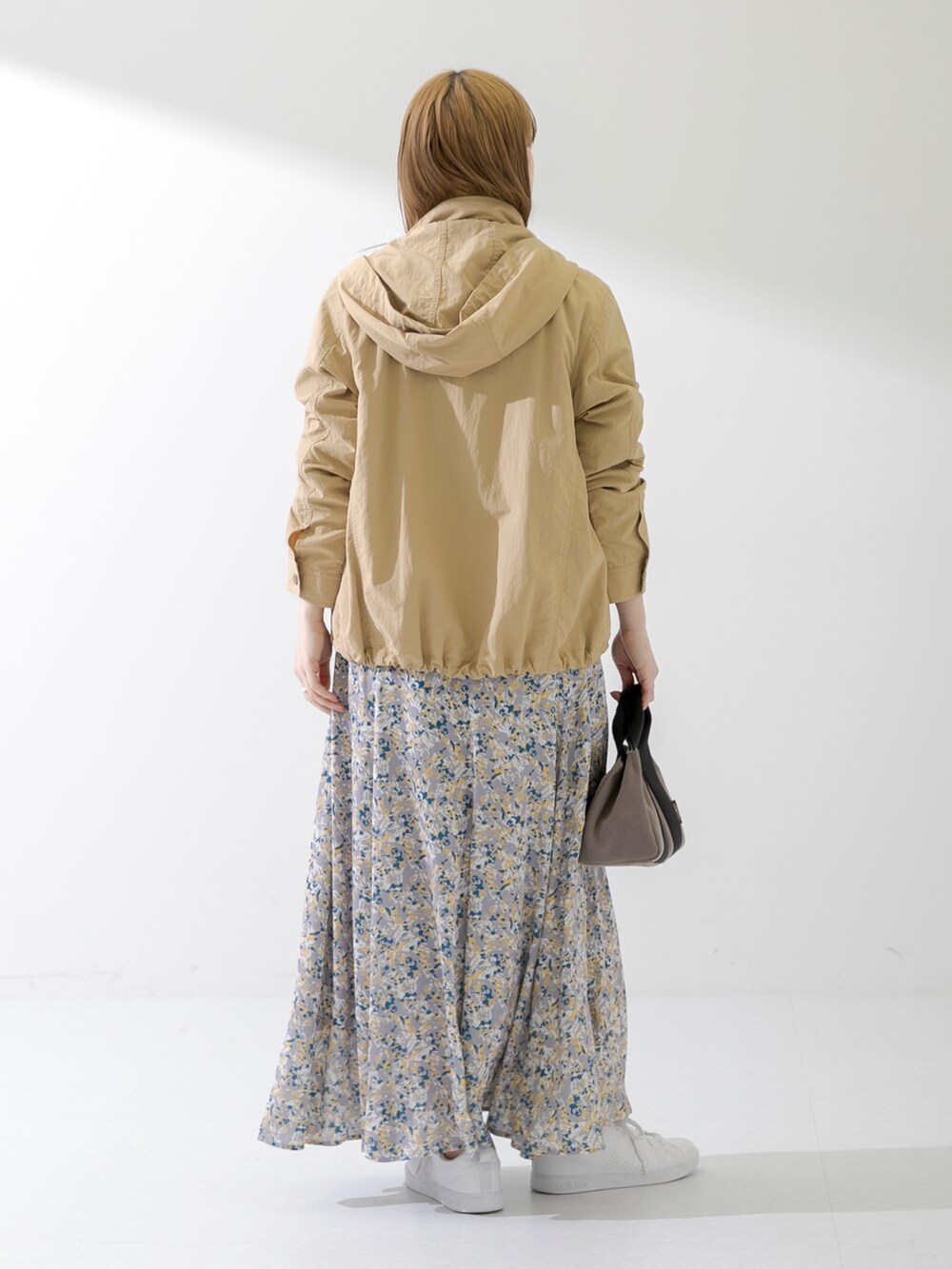 ブラウン系のハンドバッグ、ブラック系のTシャツ/カットソー、ベージュ系のマウンテンパーカーを着用したレディースの春コーディネートの3枚目の写真