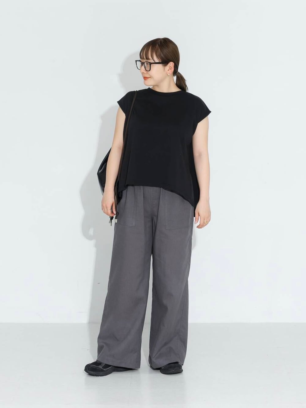 グレー系のその他パンツ、ブラック系のTシャツ/カットソー、ブラック系のバックパック/リュックを着用したレディースの春コーディネートの2枚目の写真