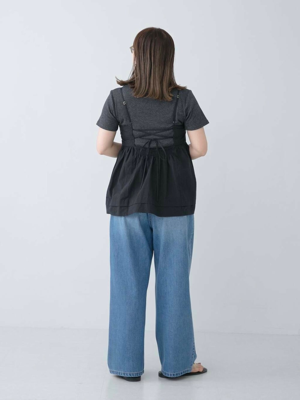 グレー系のTシャツ/カットソー、ブラック系のサンダル、ブルー系のデニムパンツを着用したレディースの夏コーディネートの3枚目の写真