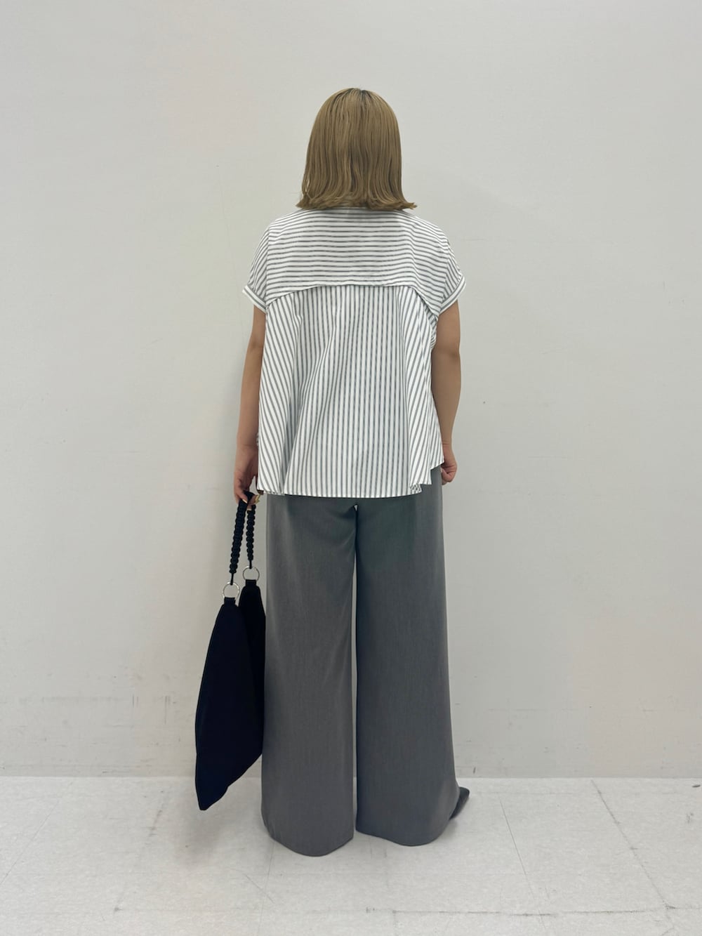 ホワイト系のシャツ/ブラウス、グレー系のその他パンツ、ブラック系のトートバッグを着用したレディースの夏コーディネートの3枚目の写真