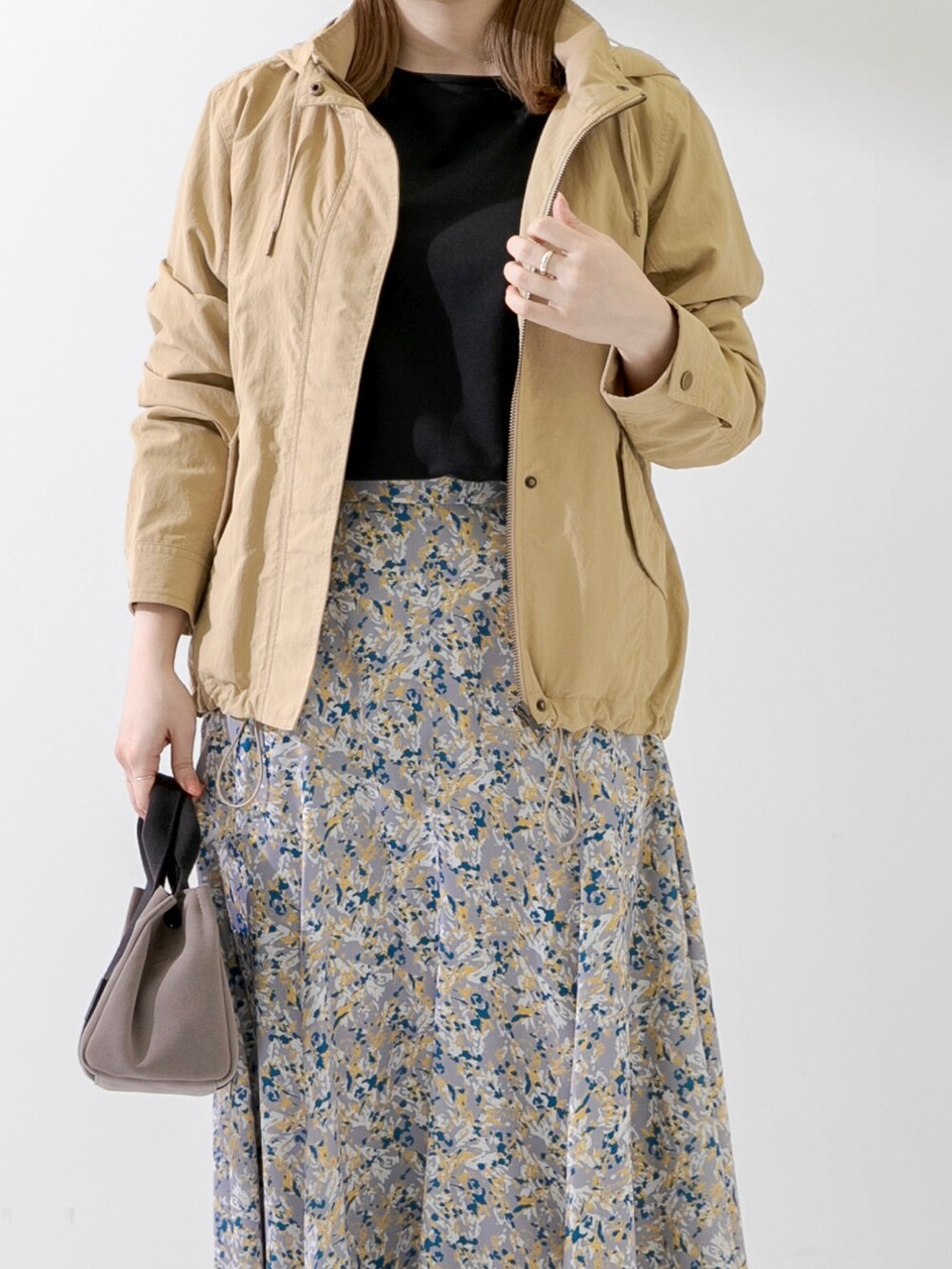 ブラウン系のハンドバッグ、ブラック系のTシャツ/カットソー、ベージュ系のマウンテンパーカーを着用したレディースの春コーディネートの5枚目の写真