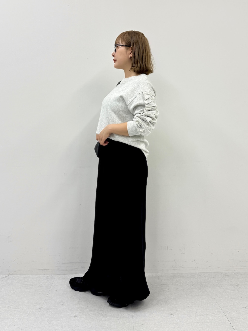 ブラック系のスカート、ブラック系のスニーカー、ブラック系のショルダーバッグを着用したレディースの春コーディネートの2枚目の写真