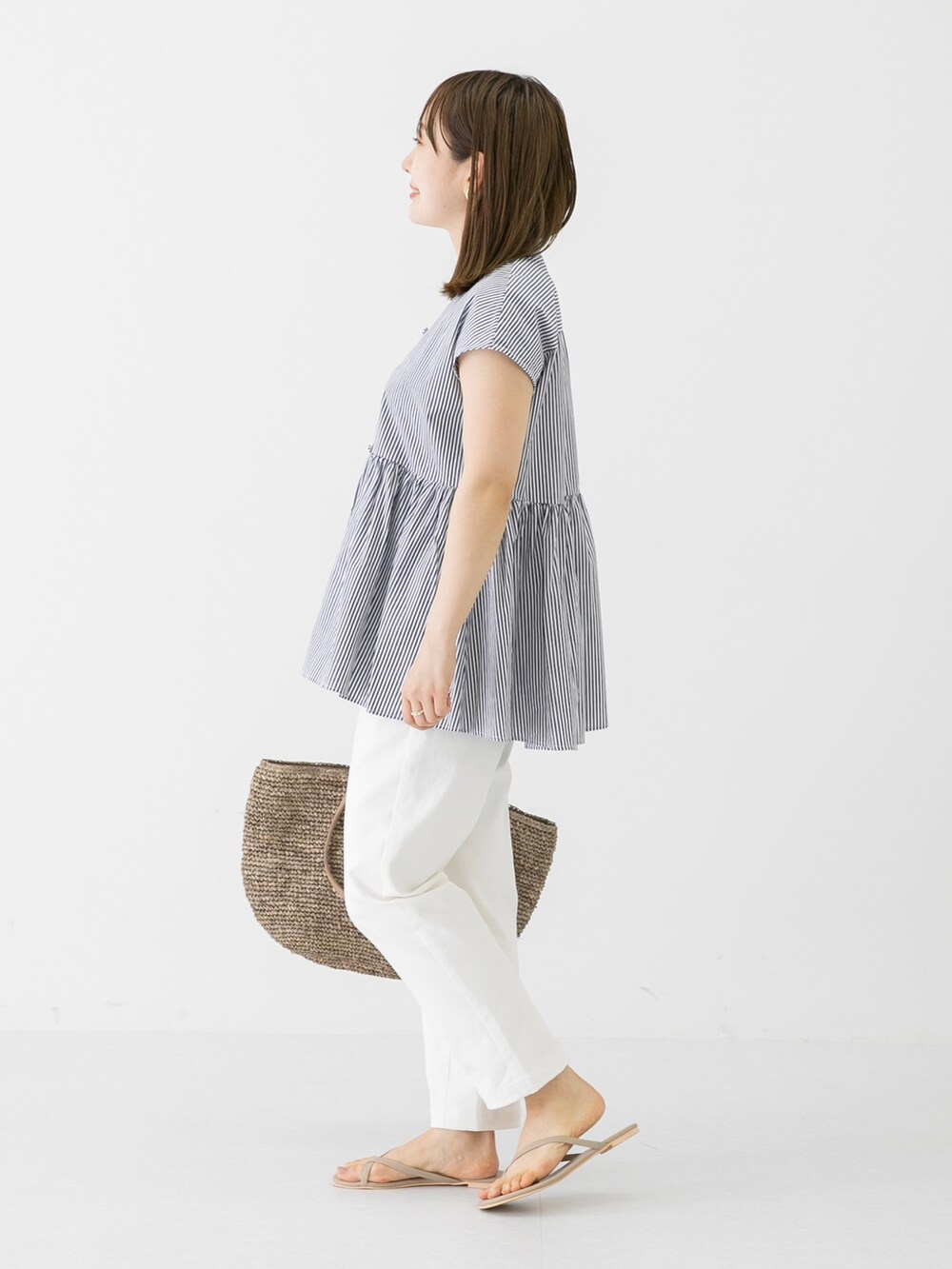 ホワイト系のその他パンツ、グレー系のサンダル、ブラウン系のショルダーバッグを着用したレディースの春コーディネートの3枚目の写真