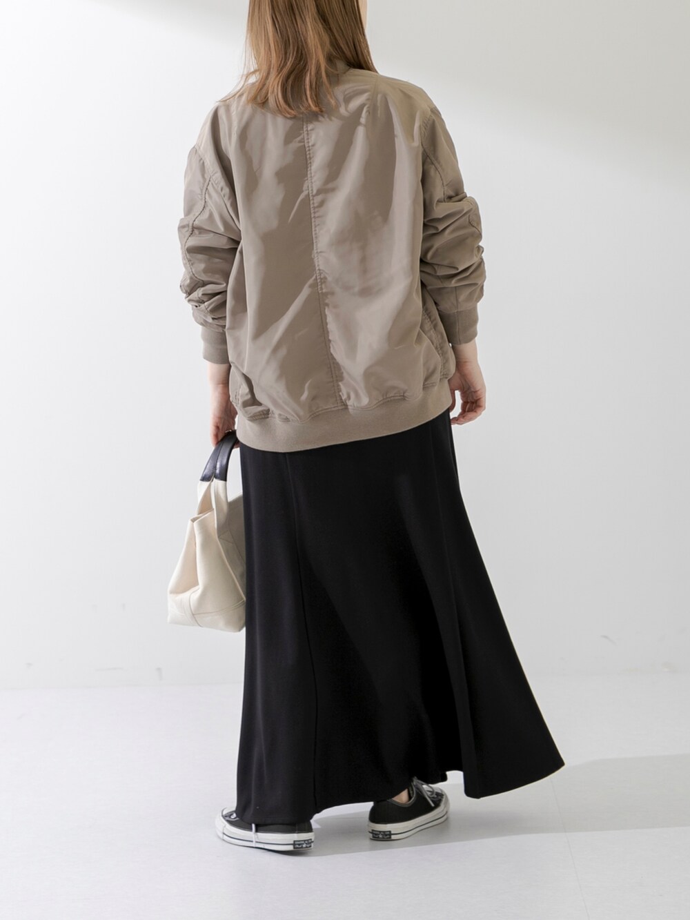 ホワイト系のトートバッグ、ブラック系のTシャツ/カットソー、ブラック系のスカートを着用したレディースの春コーディネートの4枚目の写真