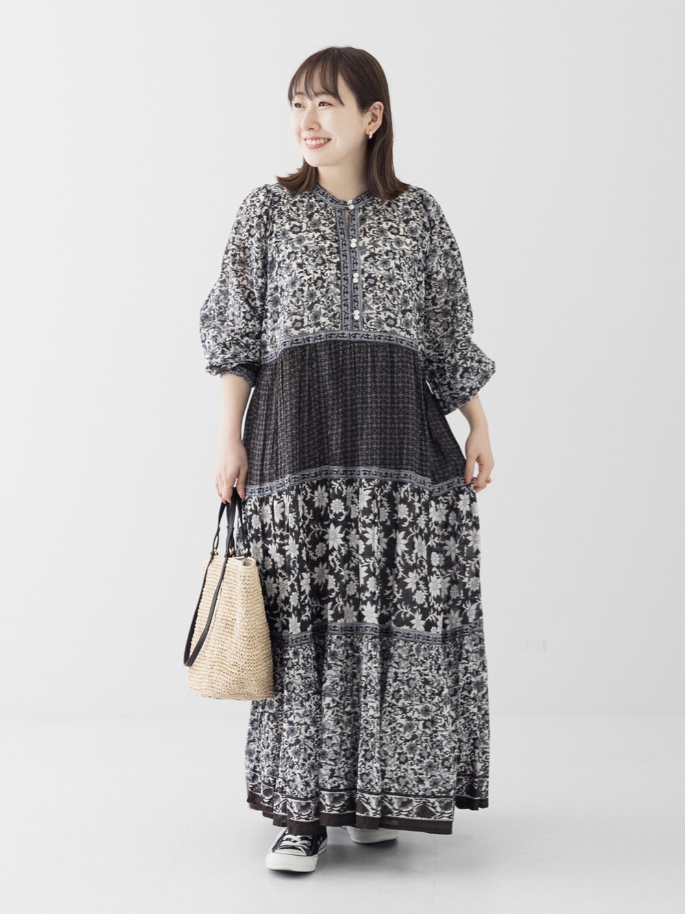 ベージュ系のショルダーバッグ、ブラック系のワンピース、ゴールド系のリングを着用したレディースの春コーディネートの2枚目の写真