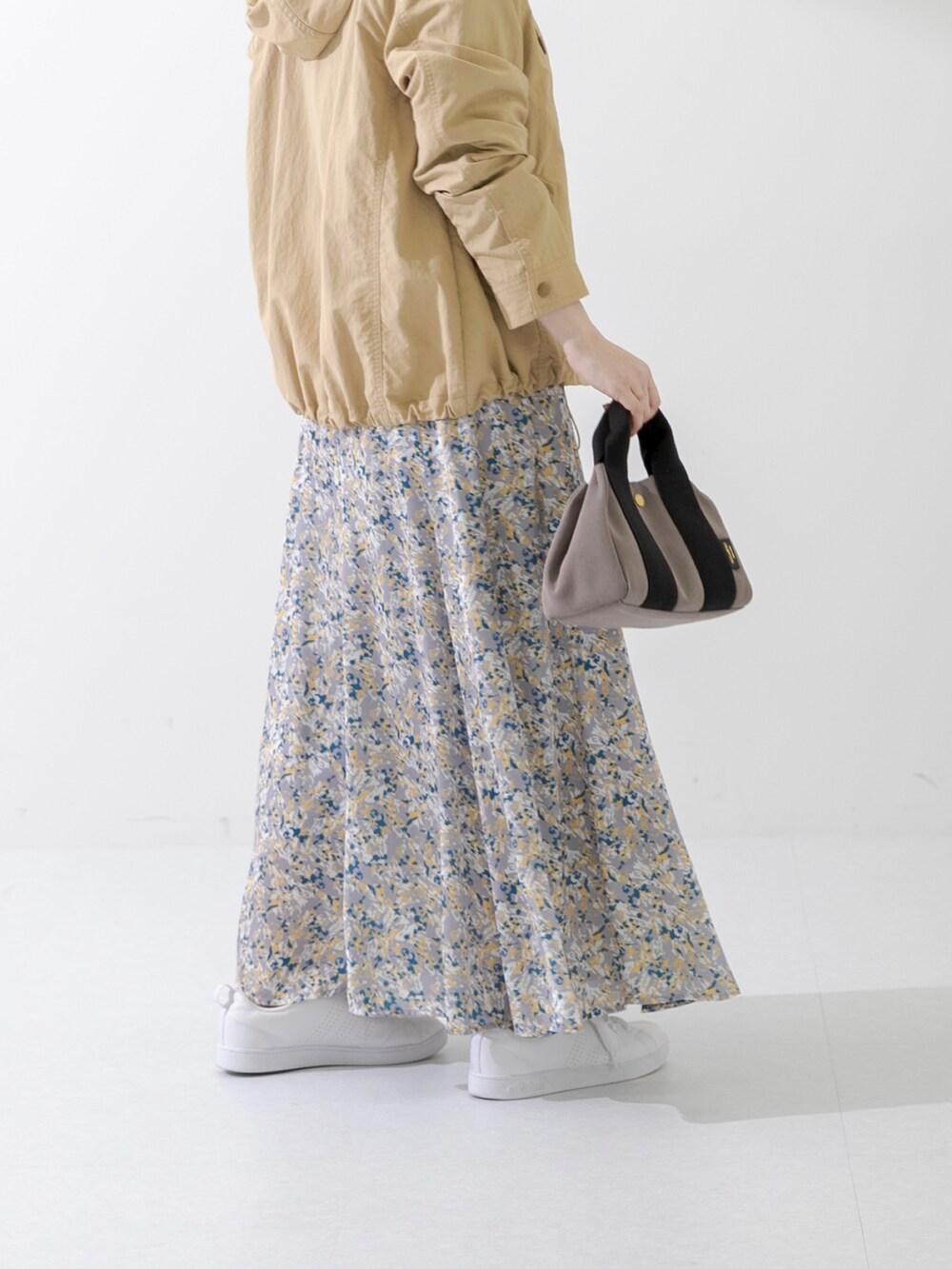 ブラウン系のハンドバッグ、ブラック系のTシャツ/カットソー、ベージュ系のマウンテンパーカーを着用したレディースの春コーディネートの4枚目の写真